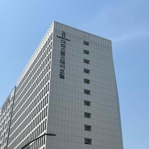 首尔First Stay Hotel的一座高大的建筑,旁边有一个标志
