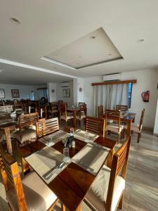 菩提伽耶菩提迦耶酒店学校的大型用餐室配有木桌和椅子