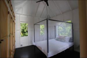 Saint MarySugar Mountain Cottage的一间卧室设有一张天蓬床和两个窗户