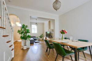 悉尼Ideal 3 Bedroom House in Chippendale with 2 E-Bikes Included的一间带桌子和绿色椅子的用餐室