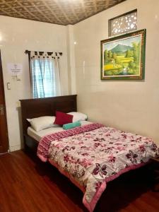 乌布Banana Home Stay Ubud的一间卧室配有一张带红色毯子的床