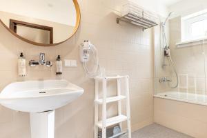 帕兰加Žilvinas Hotel的一间带水槽、淋浴和镜子的浴室