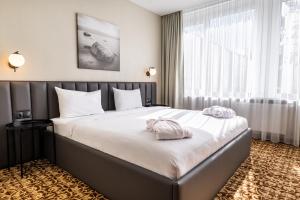 帕兰加Žilvinas Hotel的酒店客房带一张大床,带白色床单