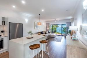 汉密尔顿岛Haven on Hamilton Island -private apartment with views & buggy Fully Renovated in 2023的厨房以及带白色台面的客厅。