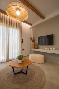 沃洛斯Palaia Luxury Suite的客厅配有咖啡桌和电视