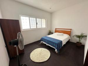 TlachicónCasa Mishi的一间卧室设有一张床、一个窗口和风扇