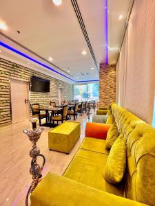 阿吉曼Zenith Smart Vacation Homes, Ajman的客厅配有黄色的沙发和桌子
