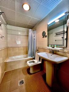 阿吉曼Zenith Smart Vacation Homes, Ajman的浴室配有盥洗盆、卫生间和浴缸。