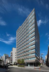大阪大阪南海辉盛庭国际公寓的城市街道上一座高大的建筑,窗户