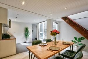 悉尼Spacious 3 Bedroom House Darlinghurst City Centre 2 E-Bikes Included的一间带木桌和绿色椅子的用餐室