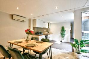 悉尼Spacious 3 Bedroom House Darlinghurst City Centre 2 E-Bikes Included的厨房以及带木桌和椅子的用餐室。