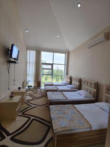 巴库Lahore Hotel Baku的客房设有四张床和平面电视。