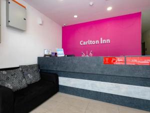 关丹OYO 89492 Carlton Inn Bukit Ubi的一间设有粉红色墙壁和柜台的等候室