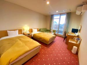 美瑛町拉温尼尔酒店的酒店客房设有两张床和窗户。