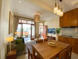 日惹Siji Nayan Vacation Home的厨房以及带木桌的起居室。