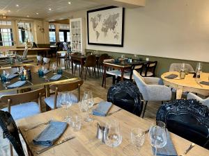 特雷伯尔当Hôtel Restaurant La Maison的餐厅设有木桌和椅子,配酒杯