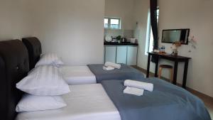 PendangD'LaMar Homestay的客房配有两张带枕头和桌子的床。