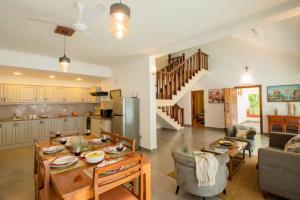 坎多林Aguada Anchorage - The Villa Resort, Candolim的厨房以及带桌椅的起居室。