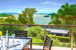 汉密尔顿岛Haven on Hamilton Island -private apartment with views & buggy Fully Renovated in 2023的海景阳台上的桌椅