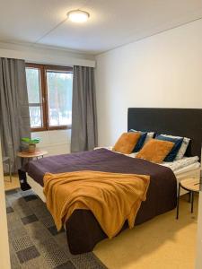奥卢Tilava 2BR-huoneisto Saunalla的一间卧室设有一张大床和两个窗户。