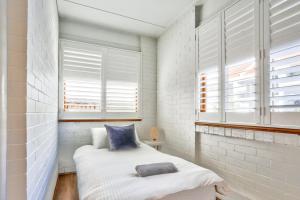 悉尼Spacious 3 Bedroom on the edge of Downtown Herford St 2 E-Bikes Included的一间小卧室,配有床和2个窗户