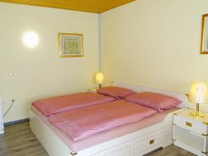Kölpinsee auf UsedomKölp - Gentz H的一间卧室配有一张带粉色床单和两盏灯的床。