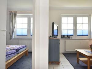 青斯特Cozy Apartment in Zingst Germany near Beach的卧室配有一张床、一张书桌和窗户。