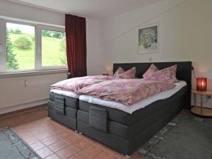 奥博瓦斯基德Apartment in Bruchhausen right on the fishing river的一间卧室配有一张带粉红色床单的大床