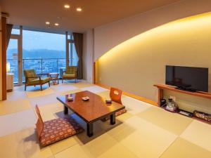 日田市三隈酒店的客厅配有桌子和电视