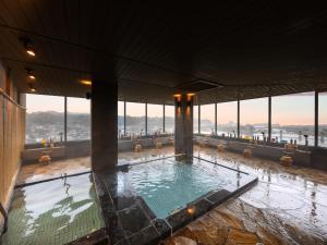 日田市三隈酒店的一座带大窗户的建筑内的游泳池