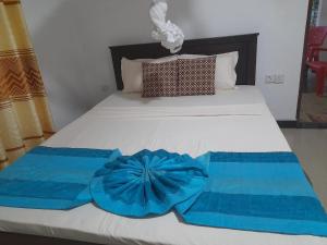 哈伯勒内The Cozy Cottage Habarana的一张带两个蓝色毛巾的床