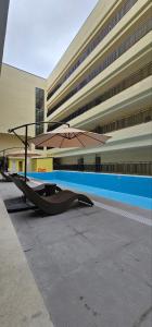 MabalacatThe Glory Hotel and Residence的一把大伞,坐在大楼前