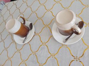 FerrolOlivers Binucot-Beach-House的桌子上摆着两杯咖啡,放在碟子上