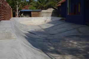 阿鲁甘湾Hangten's Surf Skate Hostel的滑冰场中的一个水泥滑板坡道