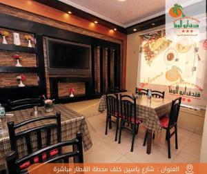 索哈杰Abo Elwafa Hotel的一间带桌椅和电视的用餐室