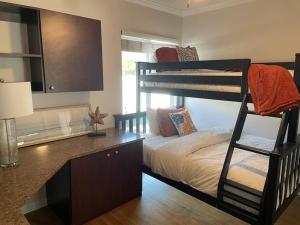 圣巴巴拉Quite Spacious, Hot Tub Near Montecito, EV Charger的一间卧室配有一张双层床和一张带一张双层床的桌子。