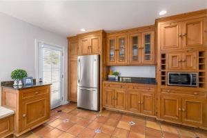 圣巴巴拉Quite Spacious, Hot Tub Near Montecito, EV Charger的厨房配有木制橱柜和不锈钢冰箱。