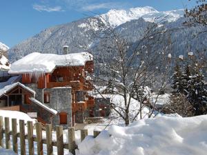 Le Villard4 6 pers holiday appartment near center of Champagny的山前有围栏的雪覆盖的建筑