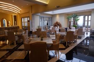 塞尔蓬格兰缇知酒店及天空酒廊的用餐室设有桌椅和窗户。