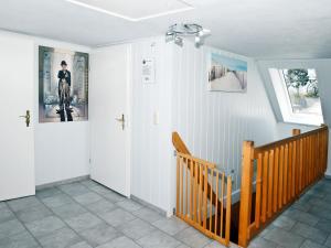 卡格斯多夫Idyllic Apartment in Bastorf with Balcony的一条带白色墙壁和木楼梯的走廊