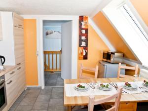 卡格斯多夫Idyllic Apartment in Bastorf with Balcony的厨房以及带桌椅的用餐室。