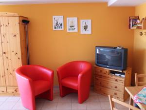 奥斯特巴德里克Comfortable Apartment near Seabeach in Rerik的两个红色椅子和一台电视机