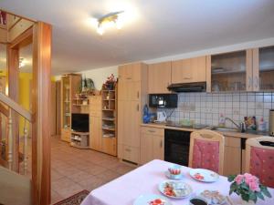 伦斯泰希地区诺伊斯塔特Holiday Home in Neustadt am Rennsteig with Pond的厨房配有木制橱柜和一张带餐具的桌子。