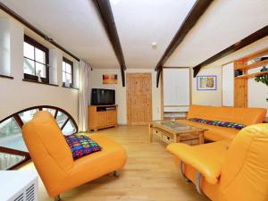 巴特皮尔蒙特博索公寓的客厅配有橙色家具和桌子