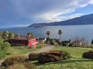 韦尔巴尼亚Villetta Primavera Suna Vista lago CIR10307200215的湖畔山丘上的红房子