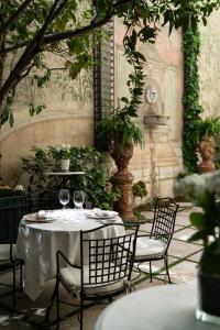 马德里Relais & Châteaux Hotel Orfila的桌子和椅子,上面装有酒杯