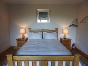 马拉莫尔Ard Na Mara, Mullaghmore, Sligo的一间卧室配有一张带两盏灯的木床。