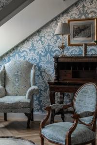 马德里Relais & Châteaux Hotel Orfila的客厅配有椅子和钢琴