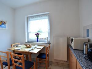 奥斯特巴德里克Tasteful Apartment in Rerik Germany with Garden的小厨房配有桌椅和微波炉。
