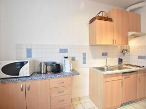 奥斯特巴德里克Tasteful Apartment in Rerik Germany with Garden的带微波炉和水槽的小厨房